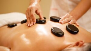 A man is taking hot stone massage.