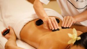 A lady is having a Hot Stone Massage Treatment.