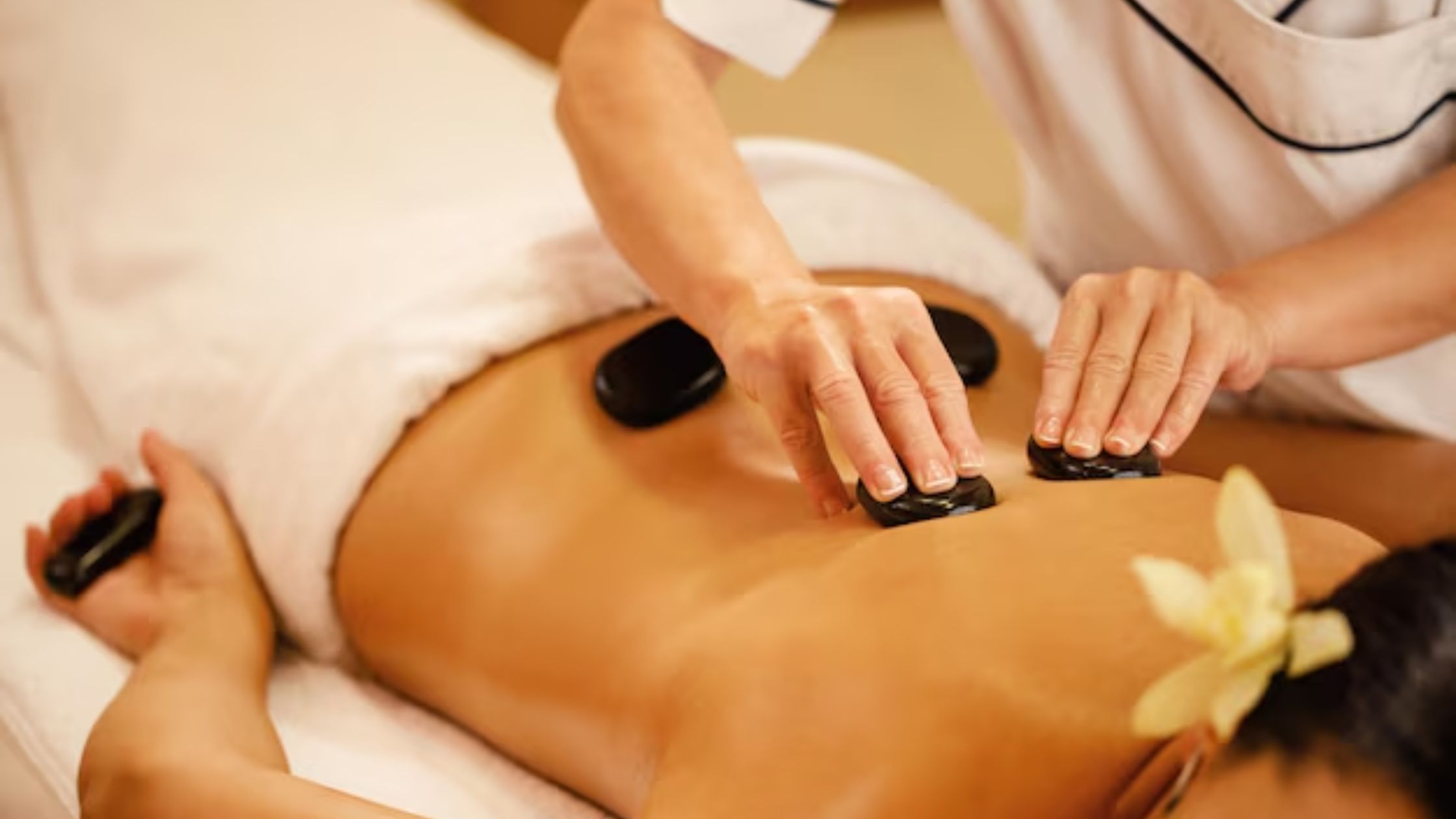 A lady is having a Hot Stone Massage Treatment.
